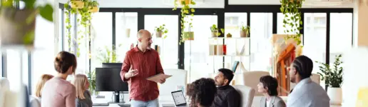 Gruppe mit Trainer im Seminarraum