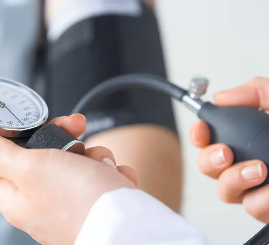 Eine Nahaufnahme eines medizinischen Fachpersonals, das den Blutdruck eines Patienten mit einem Blutdruckmessgerät misst, um zu veranschaulichen, wie genaue Messwerte dabei helfen können, den Erfolg von Weiterbildungen im medizinischen Bereich zu messen.