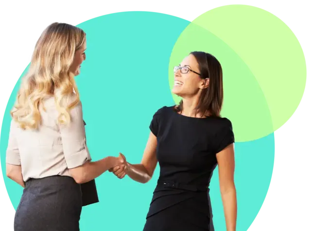 Zwei Frauen in Business-Kleidung schütteln sich die Hände und lächeln sich an, während sie vor tee- und lindgrünen Kreisen stehen, die die Zusammenarbeit in den Lernformaten für betriebliche Weiterbildung symbolisieren.